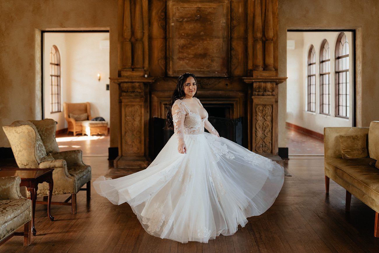 A bride twirling in her altered lace-and-tulle gown in an elegant Orlando venue